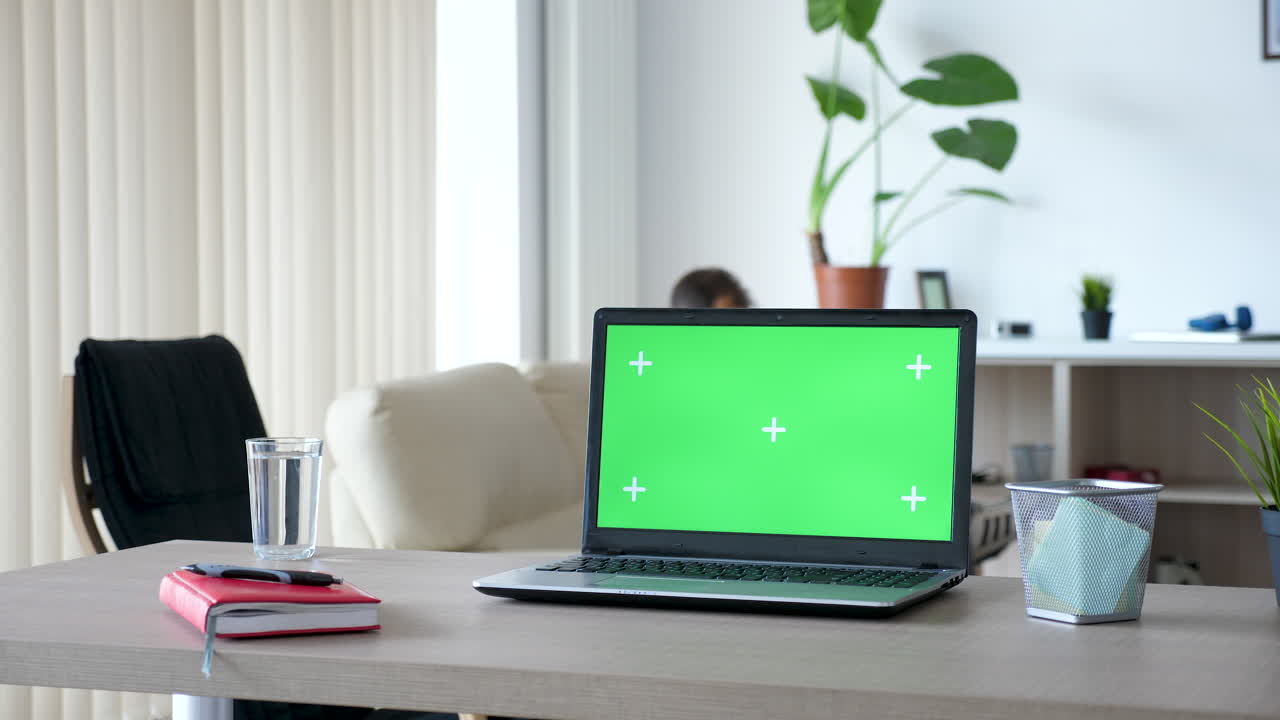 Laptop con schermo verde nelle impostazioni di ufficio