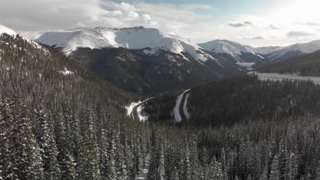 árboles-De-Hoja-Perenne-Nevados-Como-Antena-Se-Acerca-Al-Paso-De-Berthoud,-Colorado