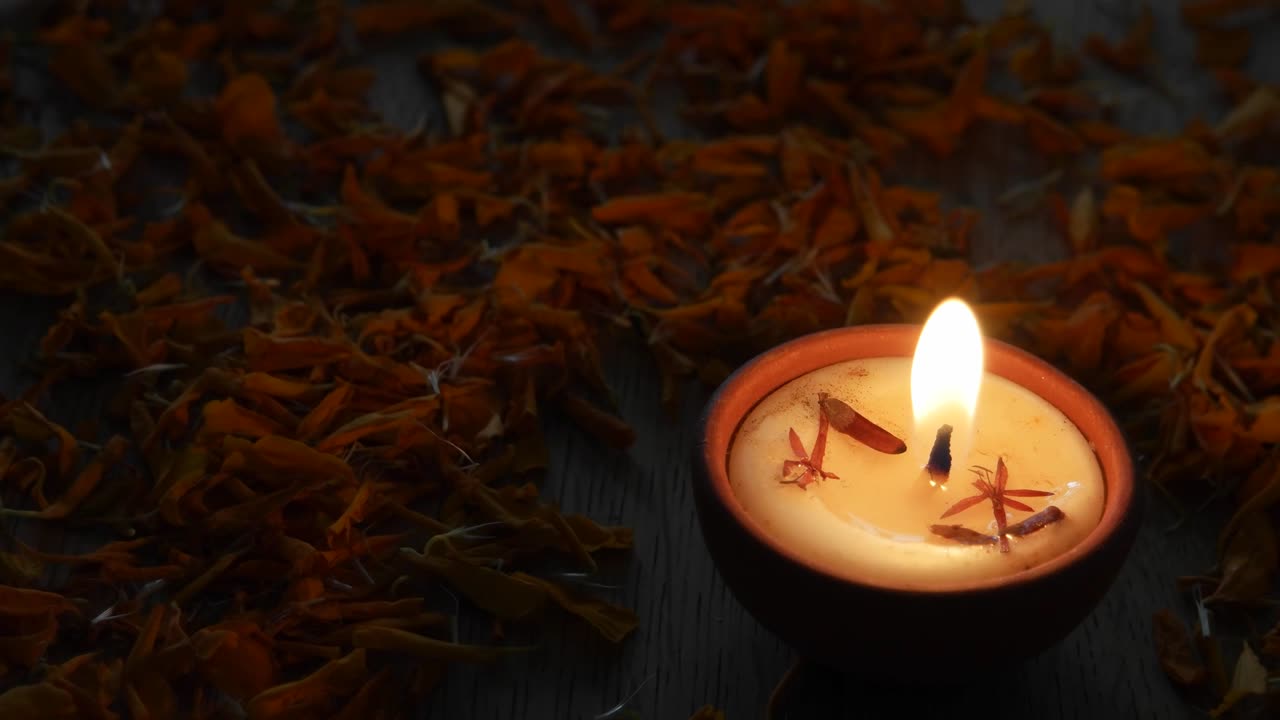 Close up Diya or a tradition lamp used for various Hindu festive celebrations for the festival of light- Diwali and also for others like Dussehra scattered with flower petals