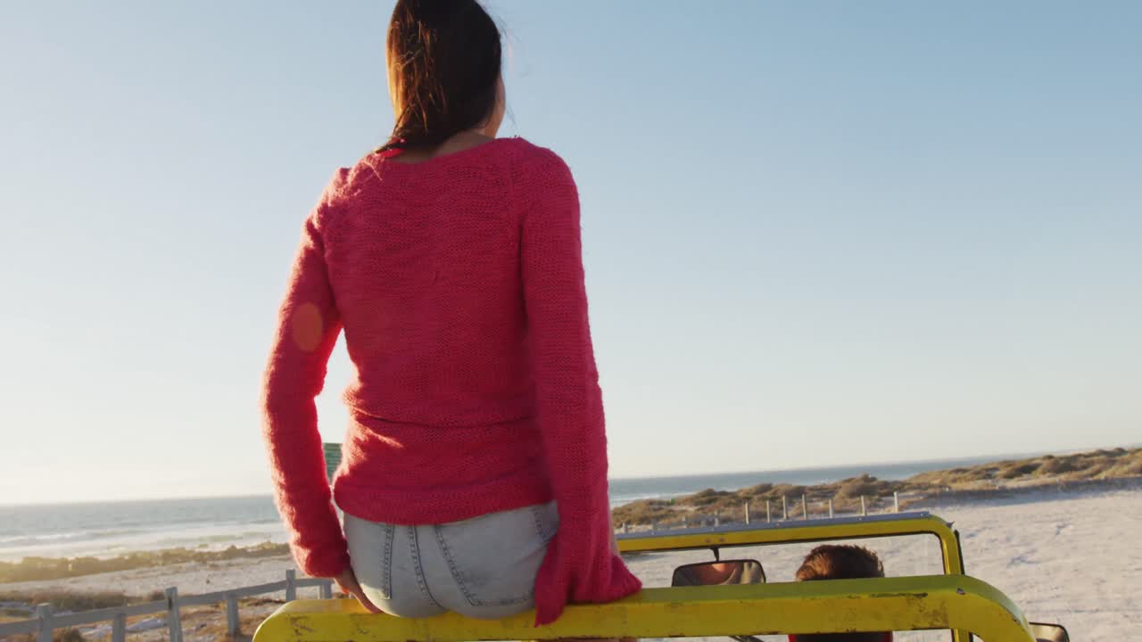 행복 한 백인 커플 이 바 ⁇ 가 에 있는 해변 버기 에 앉아 이야기 하고 있다