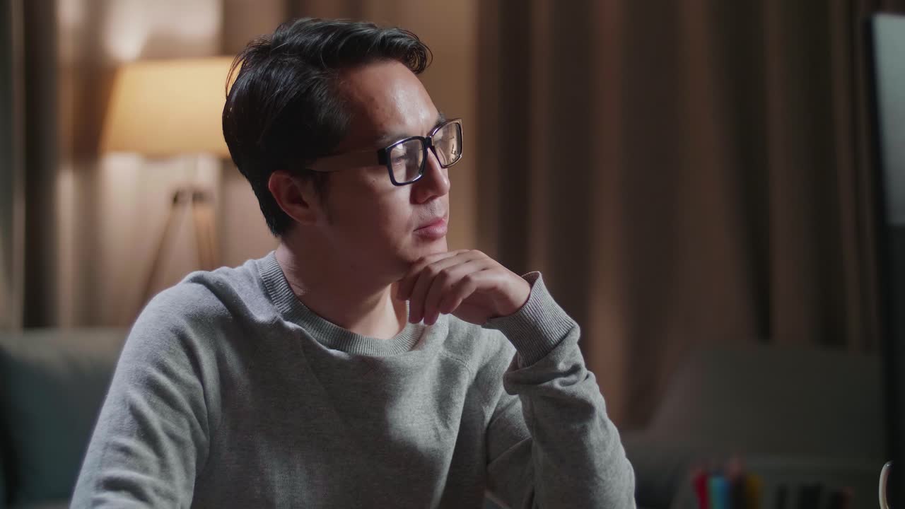 Close Up Of Asian Male Footwear Designer Thinking Then Raising Index Finger While Working On A Desktop Computer At Home