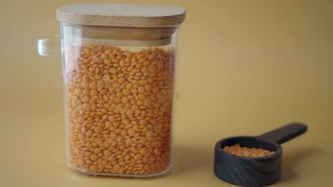 red lentils in glass jar with wooden spoon