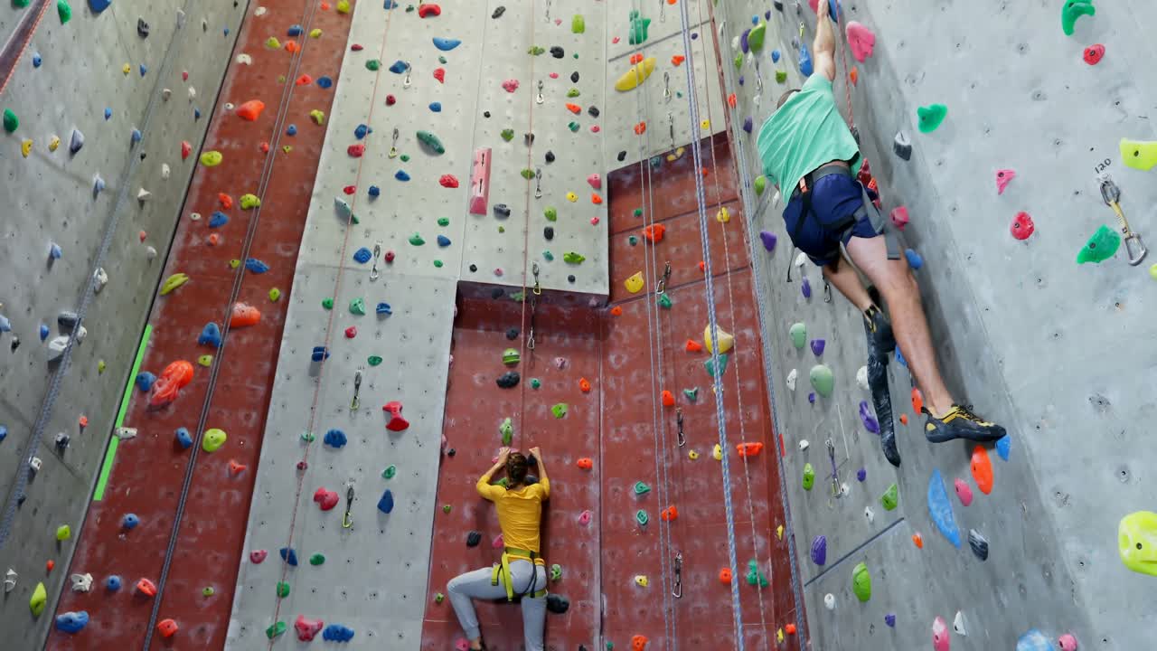 hombre y mujer practicando escalada en roca en el estudio de fitness 4k