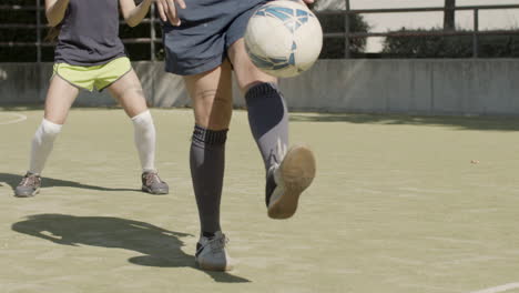 필드에 다리로 축구 공을 차는 여자 축구 선수의 슬로우 모션
