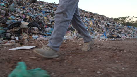 boy walking near garbage pile, slow motion