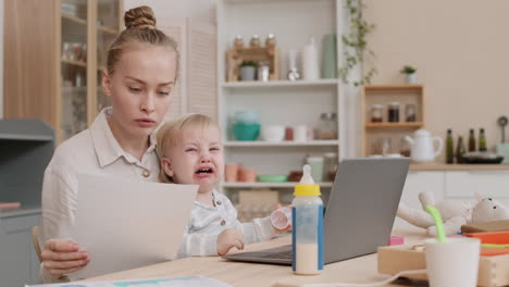 woman working and calming down toddler