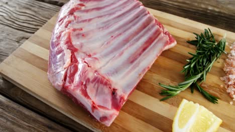 costillas de carne cruda e ingredientes en tablero de madera