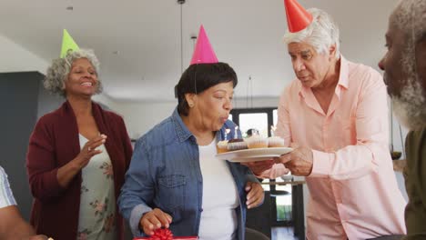 Fröhliche-ältere,-Vielfältige-Menschen-Bei-Geburtstagsfeier-Mit-Kuchen-Und-Geschenken-Im-Altersheim