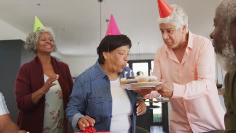 personas mayores felices y diversas en la fiesta de cumpleaños con pastel y regalos en la casa de retiro
