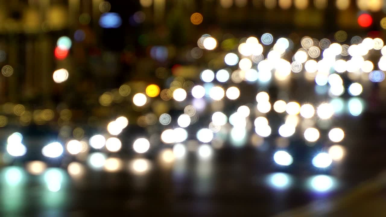 luces de automóviles de manejo nocturno de la ciudad. atasco de tráfico. luces de emergencia del coche de policía por la noche fuera de enfoque. reflectores de automóviles en la carretera mojada después de la lluvia borrosa