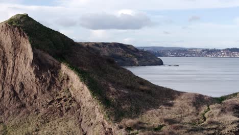 dramatic aerial reveal footage of north yorkshire coastline with scarborough town in the distance