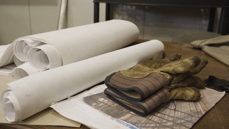 blueprints and work gloves close up on a table - construction industry