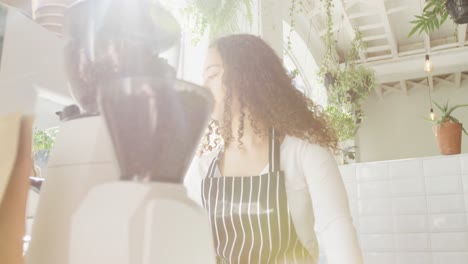 happy biracial female barista making coffee using coffee machine at cafe