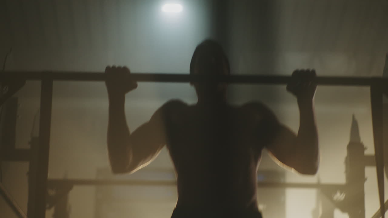 мужчина выполняет подтяжки в тренажерном зале