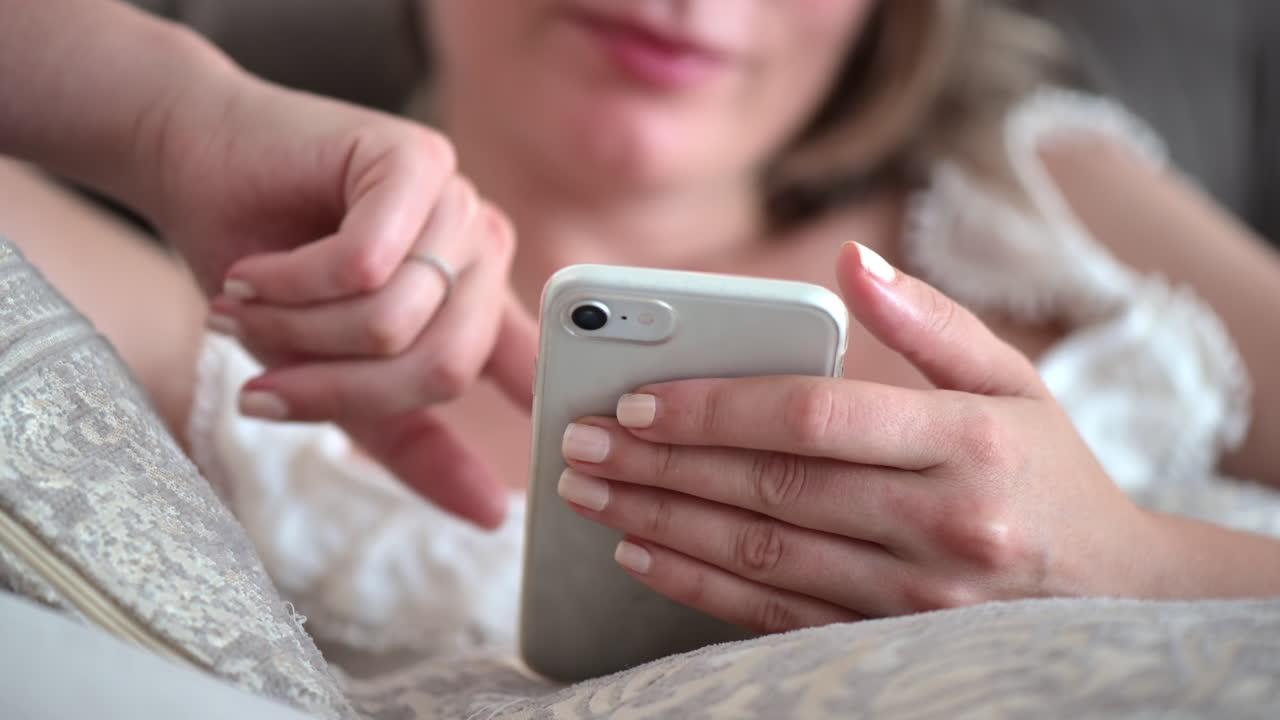 Close up of a woman lying on a couch scrolling on her phone