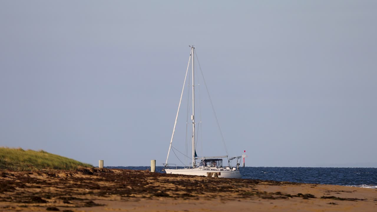 A sailboat rests peacefully by the shore