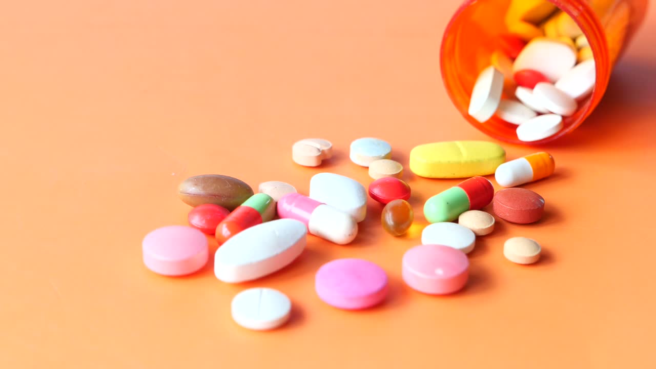 pastillas y cápsulas variadas en superficie naranja