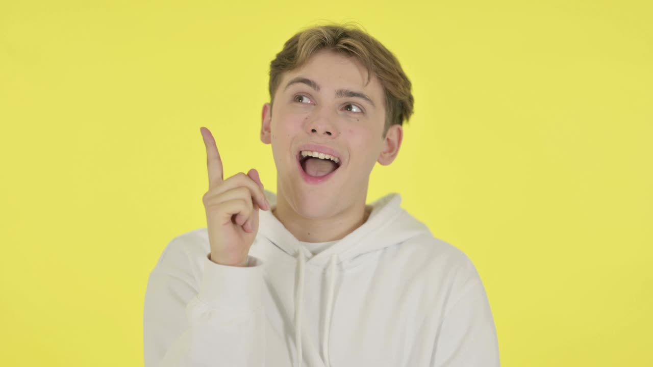 사려 깊은 젊은이가 노란색 배경에 대해 생각하고 아이디어를 얻습니다.