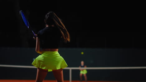 woman playing tennis at night