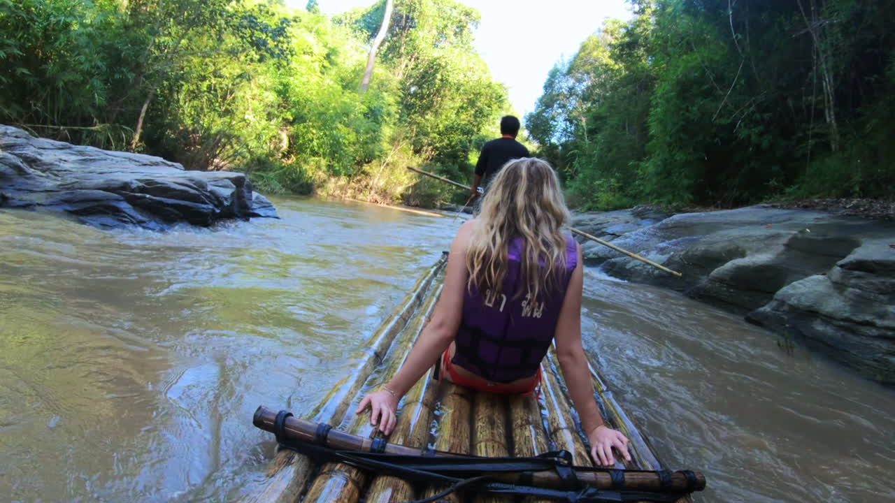 chica rubia rafting en bambú en tailandia asia en el río de la selva