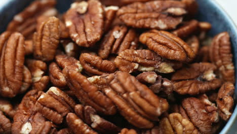 Tazón-De-Nueces-Pecanas-Girando-En-Un-Recipiente-Azul