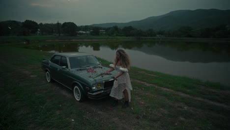 Woman near a Vintage Car by a Lake