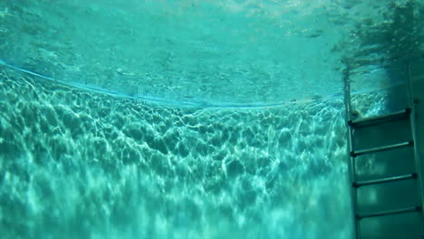 person diving underwater in a pool