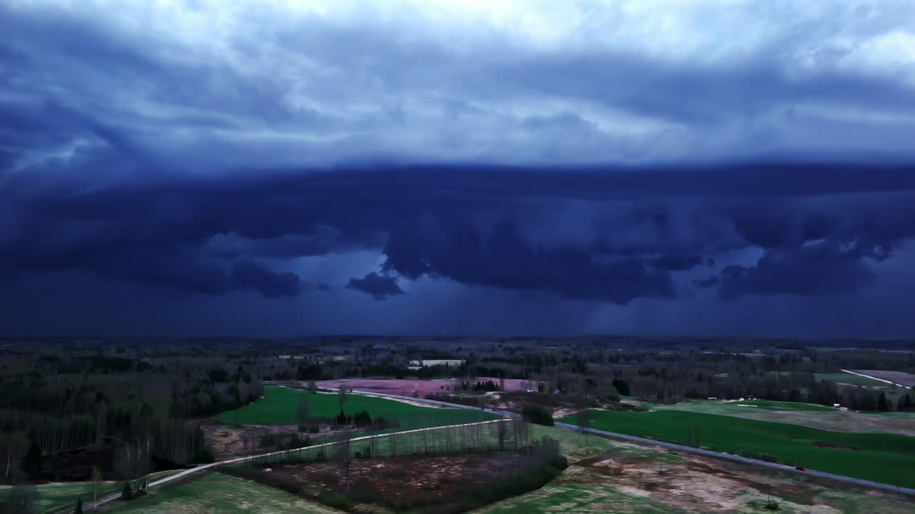 Drone footage of a landscape under dark, threatening storm clouds.