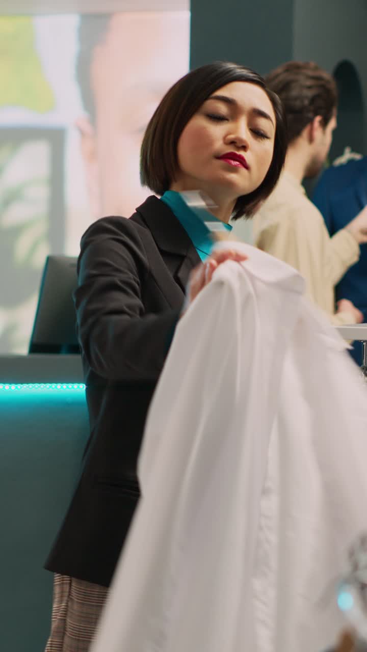Vertical video: Asian woman shopping in fashionable clothing store
