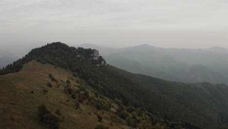 Fast-flying-towards-rock-formation-over-autumn-trees,-Aerial-wide-shot,-Slovakia