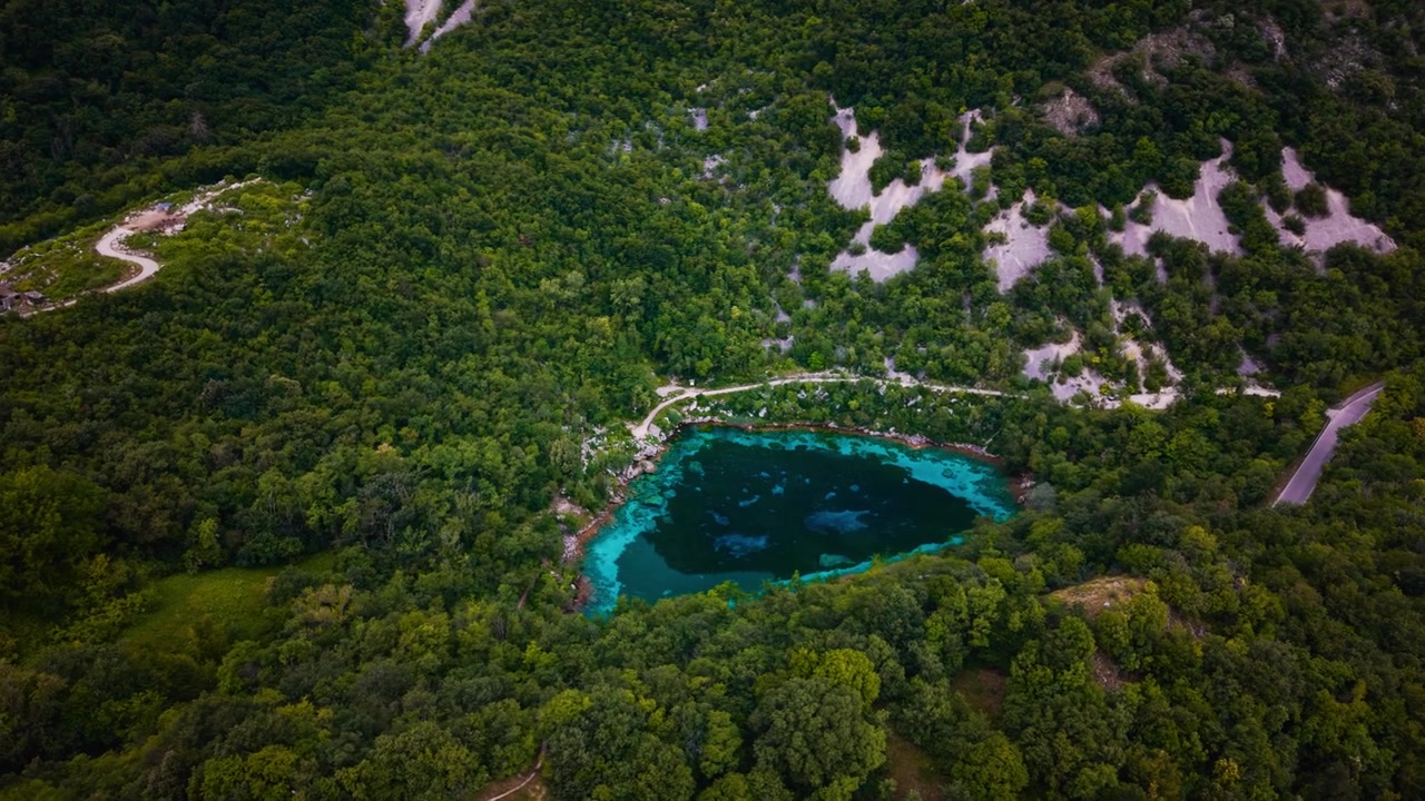 Lago alpino cristallino Lago Cornino circondato da alberi verdi e lussureggianti, Italia. Ripresa aerea con drone dell'acqua blu.