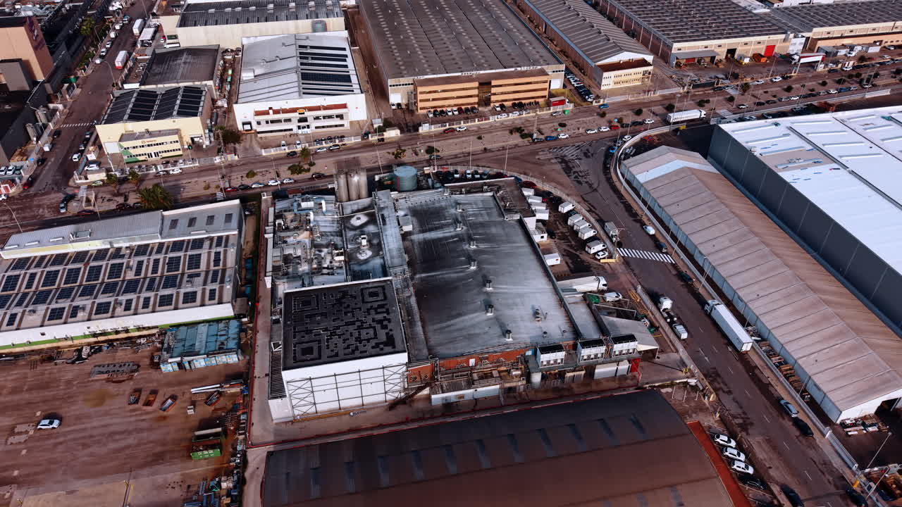 Alicante, Spain, 8 February 2026: Aerial view of industrial district and factory rooftops. Dense industrial zone with multiple warehouse buildings, solar panels, and trucks in the parking area