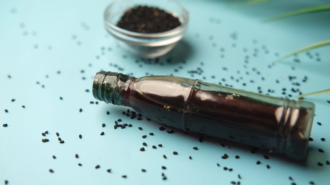 Black cumin oil on a container on blue ,