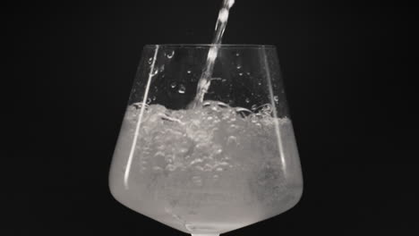 sparkling water pouring ice glass closeup slow motion. organic cocktail concept