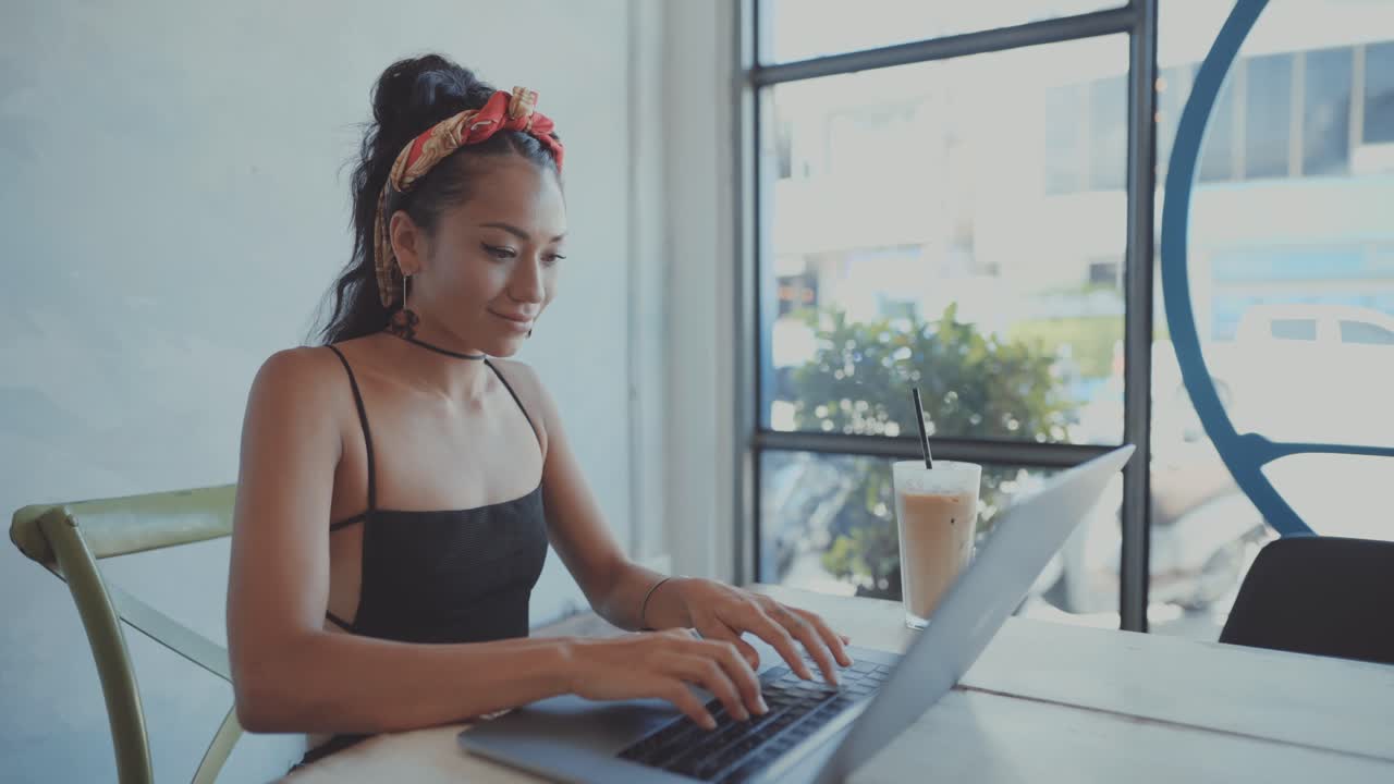 Woman working on laptop in a cafe