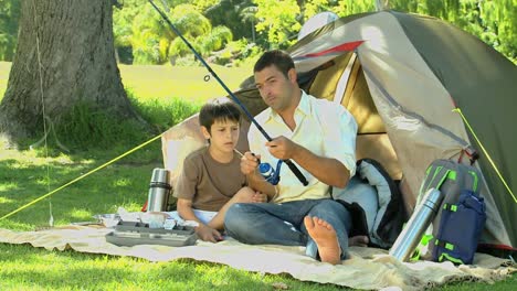 father teaching the use of the fishing rod to his son