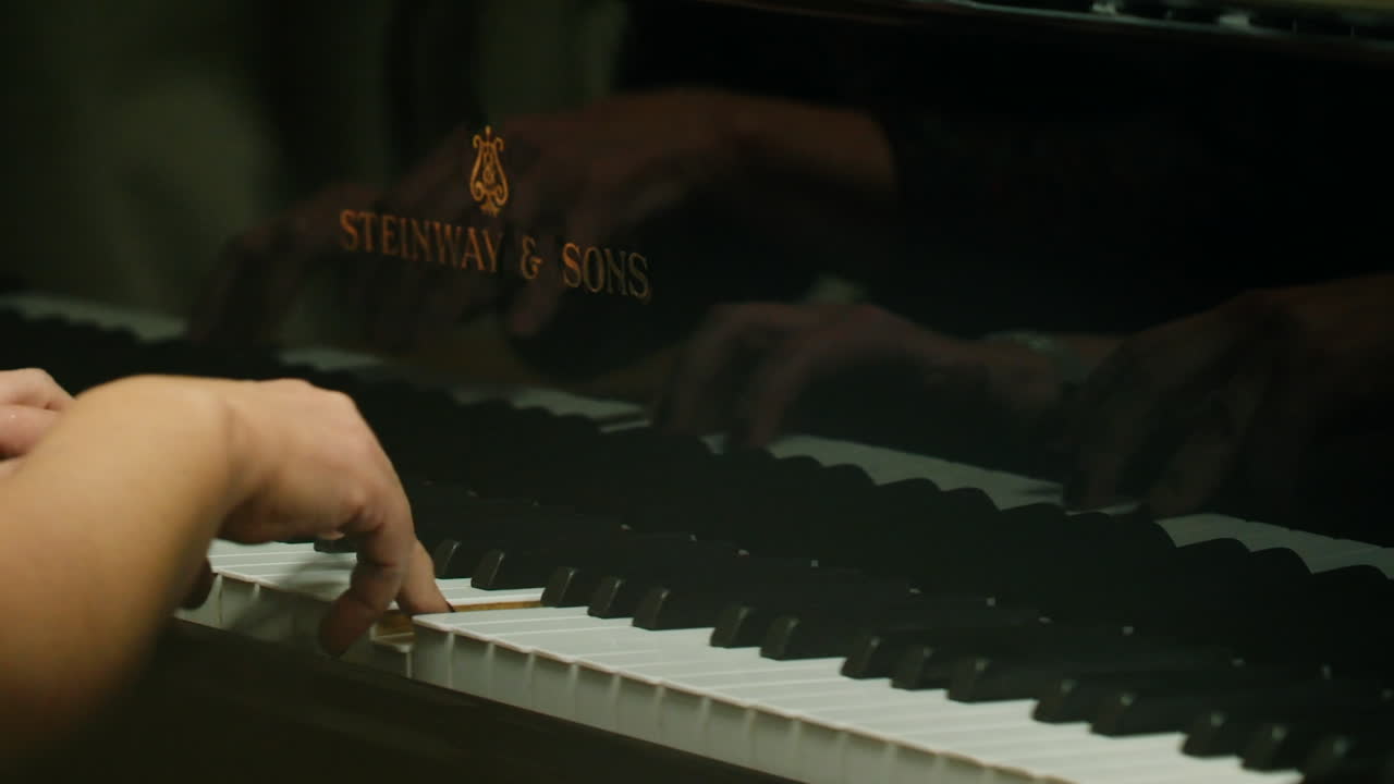 Closeup of hands playing a Steinway piano