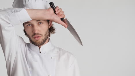 un homme caucasien devant une caméra sur un fond blanc.