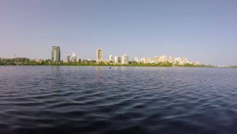 olas sobre una laguna con edificios en el horizonte
