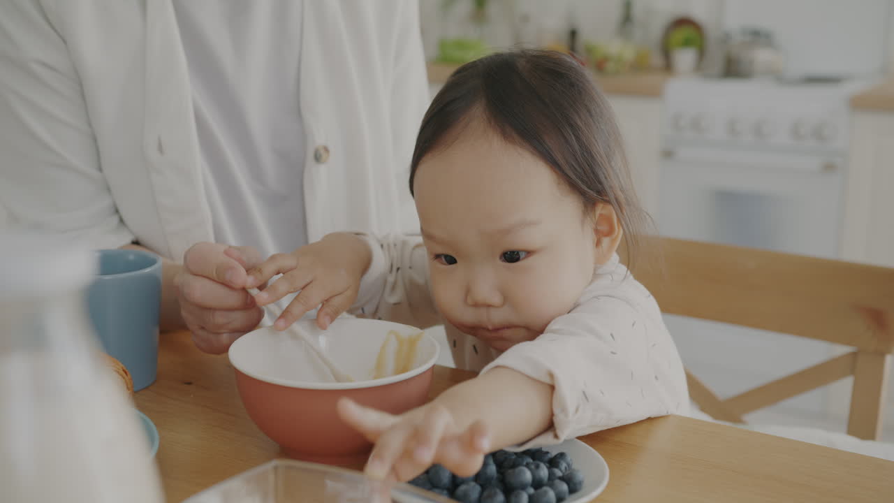 Baby Eating Breakfast with Mom