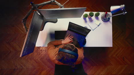 administrador que utiliza la configuración de la pc multimonitor y la computadora portátil para terminar las tareas, toma aérea