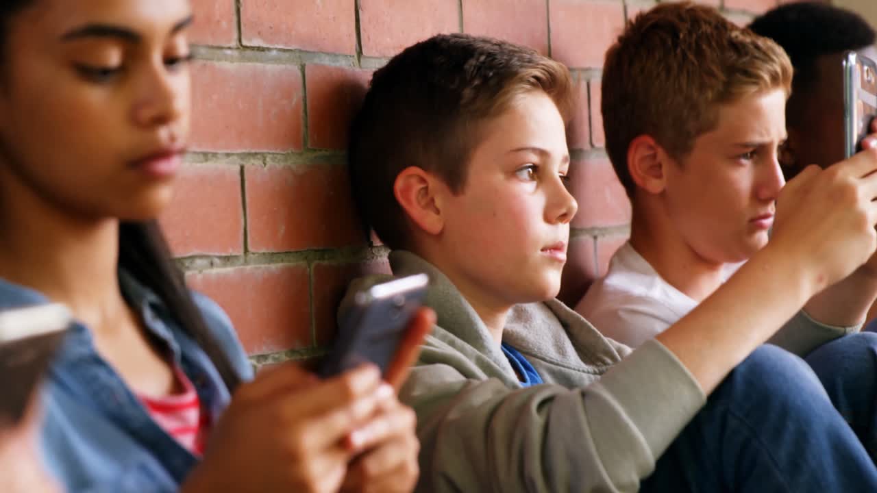 휴대 전화 4k를 사용하는 학교 친구들의 그룹