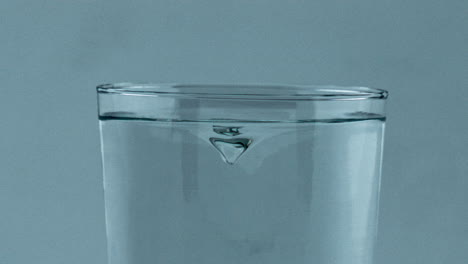 closeup aqua tornado inside transparent glass. beverage whirlpool clean vessel