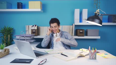 Young-man-casually-talking-on-the-phone-and-looking-at-laptop-at-the-same-time.