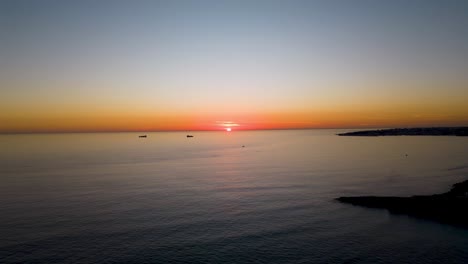 Vista-Aérea-De-Lapso-De-Tiempo-Volando-Sobre-El-Océano-Hacia-La-Espectacular-Puesta-De-Sol-Cerca-De-La-Bahía-De-Cascais