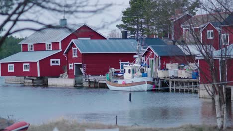 Explore-a-quaint-Swedish-Archipelago-village-in-spring-with-handheld-footage-Red-houses,-fishing-boats,-and-vibrant-nature-scenes-highlight-the-idyllic-charm-and-peacefulness-of-this-coastal-community