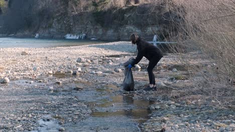 teamwork cleaning plastic on the beach. volunteers collect trash in a trash bag. plastic pollution and environmental problem concept. voluntary cleaning of nature from plastic. greening the planet