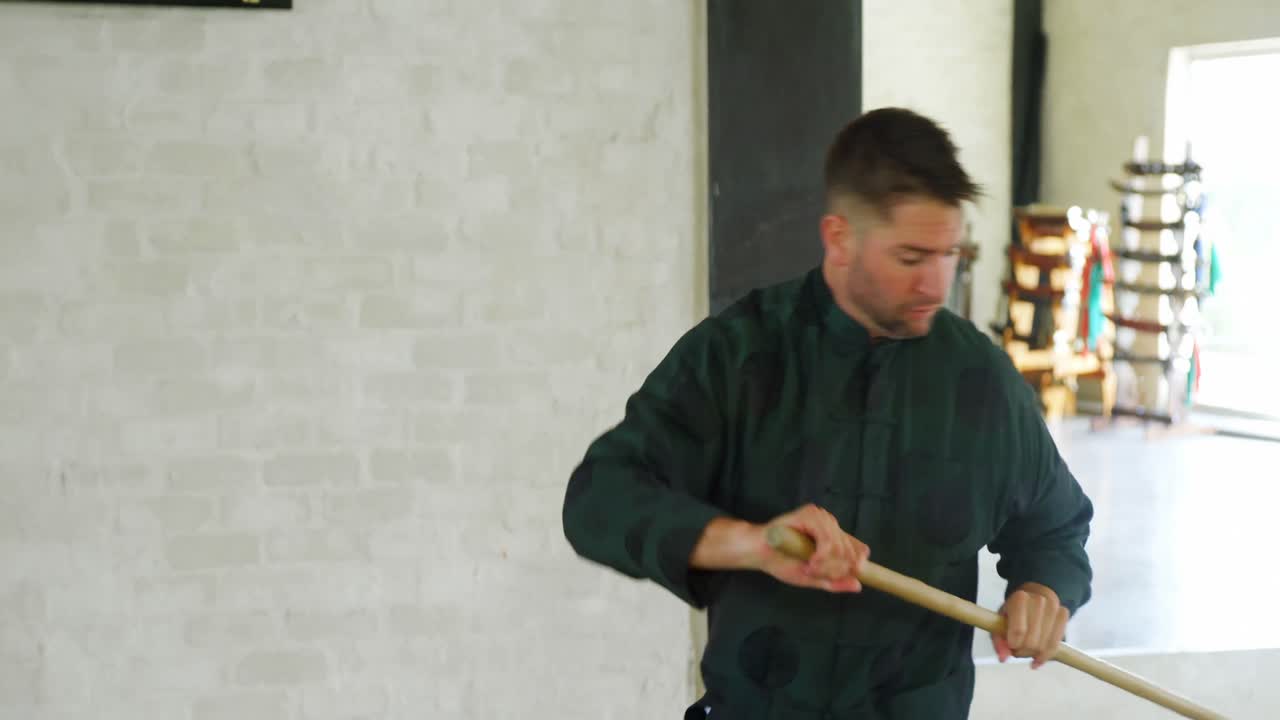 Kung fu fighter practicing martial arts with whip stick 4k