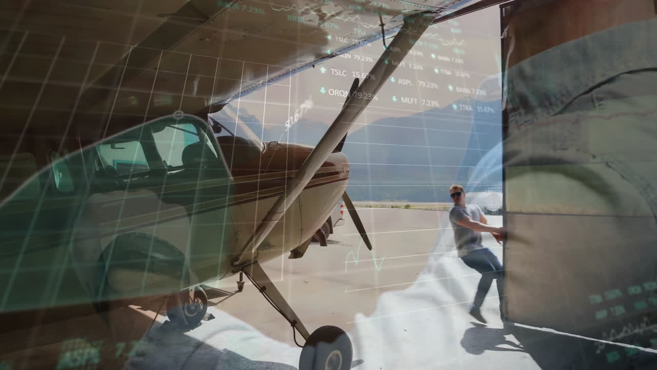 Pilot pulling open hangar door on airport apron, digital financial graphs floating over airplane