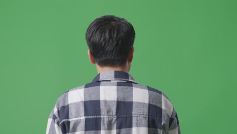 back view close up of asian man walking and looking around in green screen background